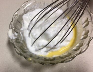 蓝天白云蛋糕卷,取出30克打发好的蛋清到小份的蛋黄糊里，用刮刀翻拌均匀。