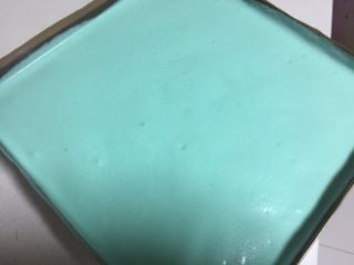 蓝天白云蛋糕卷,剩余全部蓝色蛋糕糊倒入烤盘，晃动烤盘使蛋糕糊均匀的铺在烤盘上，送入烤箱上下火150度25分钟。