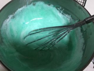 蓝天白云蛋糕卷,把三分之一的蛋清加入蓝色的蛋黄糊里翻拌均匀，再把蛋黄糊全部加入蛋清里翻拌均匀。