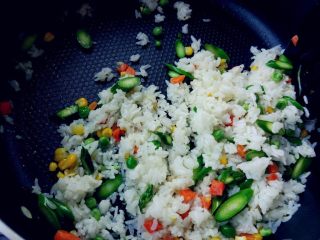 芦笋咸蛋炒饭,倒入米饭，用锅铲将米饭压炒匀