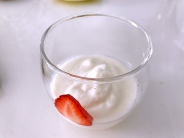 草莓酸奶杯，吃出生活好营养,将酸奶倒入杯中三分之一，草莓片紧贴在杯子内壁上，贴一圈，一定要贴紧。
