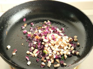香菇酱五彩菠萝饭,放入香菇丁和紫甘蓝丁翻炒。