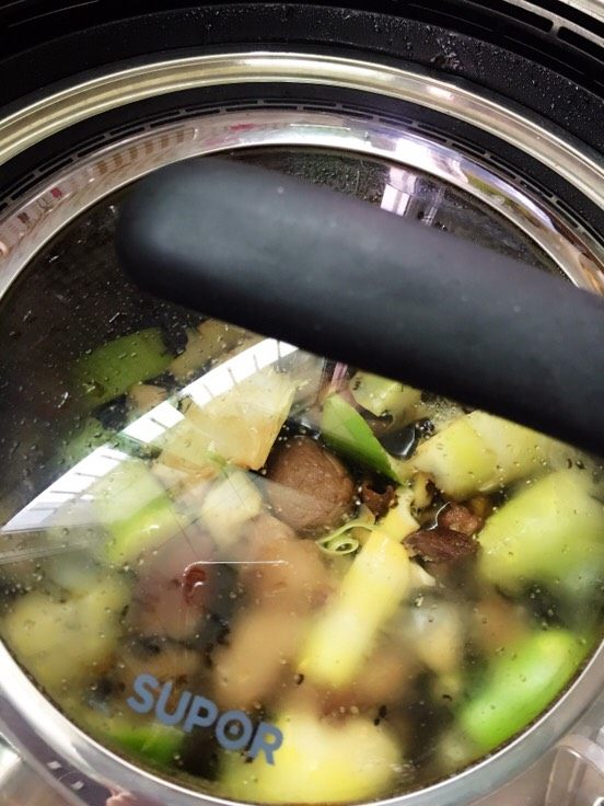 梅菜煨春笋,盖上锅盖焖煮至汤汁滚开。