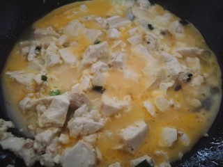 鸡蛋刨豆腐,炒到豆腐稍微有些出水时，将蛋液均匀的倒在豆腐上。