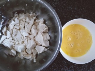 鸡蛋刨豆腐,豆腐用勺子压碎成小块儿（约大拇指甲盖的大小），两个鸡蛋打散成蛋液。
