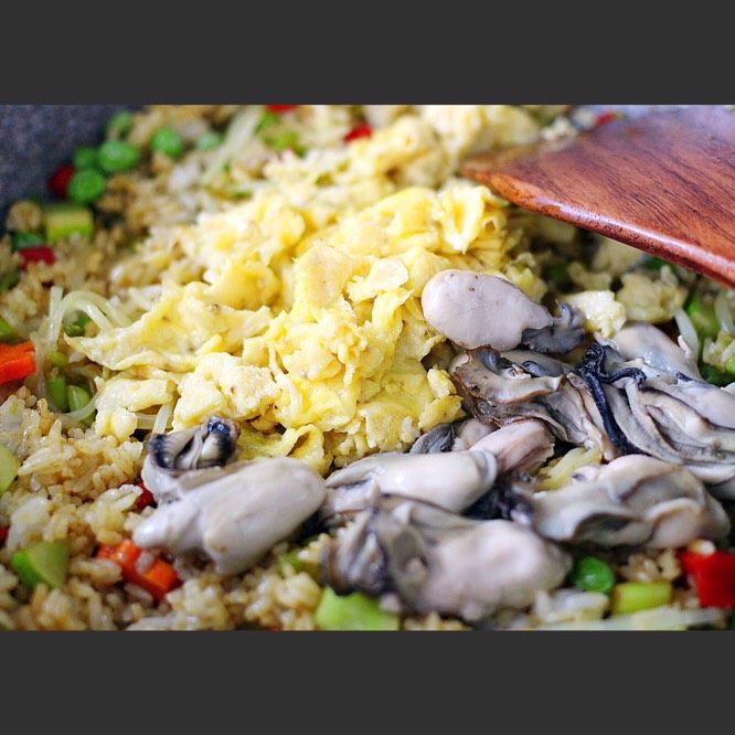 海蛎子咖喱炒饭#人民的美食#,加入蒸熟的海蛎子肉和炒好的鸡蛋，继续翻炒均匀