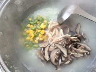 香菇鸡肉粥,放入鸡丝、玉米粒、青豆、香菇，加一点盐，搅拌均匀。