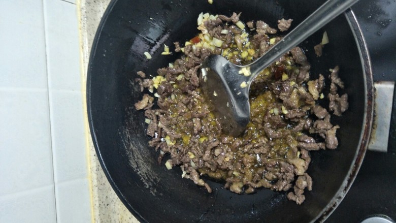 回味无穷的私房牛肉,油开后，把牛肉和姜蒜一起翻炒