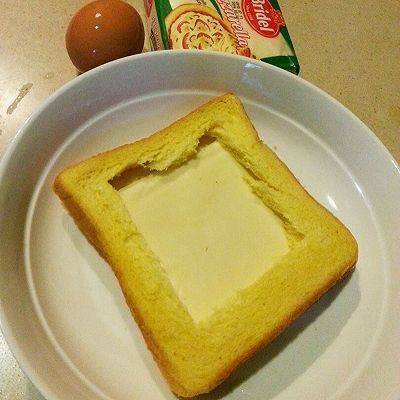 法式早餐 : 干酪太阳蛋吐司,把一片干酪铺到2片面包中间，四周压紧一点