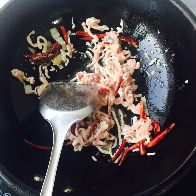香辣肉丝,锅内油烧热放入川椒，然后放肉丝翻炒到变色。