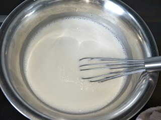 椰奶雪花糕,椰浆牛奶一边煮一边搅拌让白糖融化，然后煮翻滚。