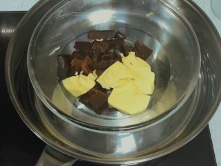 巧克力燕麦能量球🍫,将黄油和黑巧克力碎块放在碗中隔水小火加热 