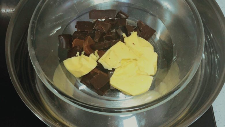 巧克力燕麦能量球🍫,将黄油和黑巧克力碎块放在碗中隔水小火加热 