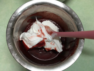 红丝绒蛋糕卷,取1/3蛋白霜放在红丝绒蛋黄糊中。（这时预热烤箱，温度为170度）