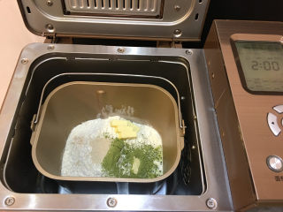 抹茶凤梨全麦面包,将面包材料全部放入东菱1352AE-3C面包机中，启动面包机标准面包菜单进行揉面。