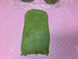 抹茶凤梨全麦面包,醒面结束后取一个面团擀起长方形，翻面后底部按薄。