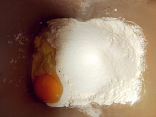 蓝莓奶油小餐包,将主料中的材料依次放入面包桶内，选择甜面包程序，开始和面。牛奶用室温或冷藏后的温度都可以。酵母粉和盐糖须用高筋粉隔开，否则会影响发酵效果。