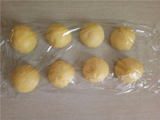 椰蓉花朵面包,醒发结束，将面团分成10个小面团滚圆盖上保鲜膜，松弛15分钟。