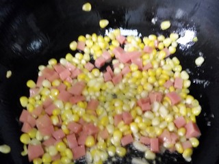 玉米火腿粒,玉米炒三分钟左右后放入火腿粒，加入醋，食用盐