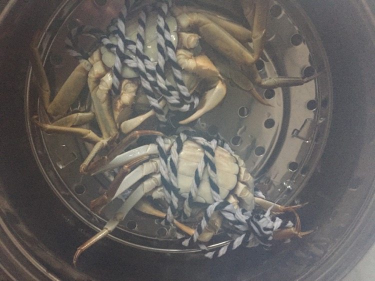 螃蟹螃蟹+#人民的美食#,蒸锅水烧开后，肚子朝上摆好螃蟹。（看看看，腿没绑紧全挣脱出来了。）赶紧盖上锅盖，约两分钟后转小火15分钟即可