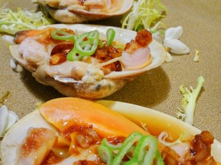 蒜香蛤蜊,盘中放上苦苣点缀，放上蛤蜊。