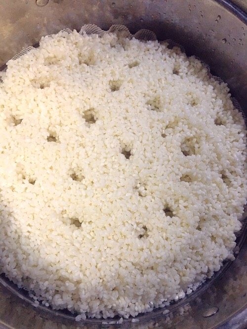 酒酿,把糯米放到蒸屉里，为了方便糯米蒸熟，我们一般用筷子在上面戳上几个小洞，这样是能使糯米熟的快。