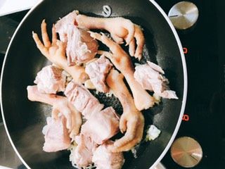 苦瓜黄豆猪骨鸡脚汤,将焯过的鸡脚和猪骨配合葱姜蒜和油爆锅翻炒一下