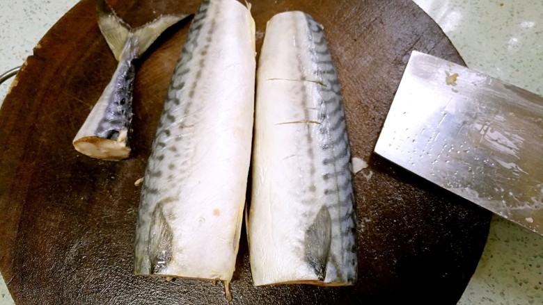 盐煎青花鱼,切去头部，切断尾部，从脊背处横刀分切成两半。
