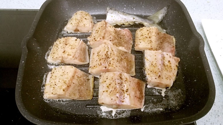 盐煎青花鱼,把麦饭石煎锅小火加热，倒一点食油，用小扫子抹开。把青花鱼鱼皮朝下，一块一块放进锅里，小火煎制。