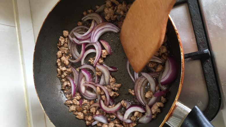自制意面🍝,起油锅，放入猪肉碎开始煸炒，肉变色后就可以放入洋葱一起爆炒一下。