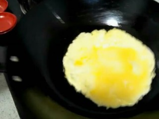 家常炒面,均匀旋转炒勺，把鸡蛋煎制成饼状。盖在炒面上。