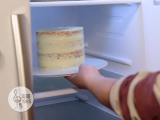 黄桃裙边蛋糕,用蛋糕小抹刀来做蛋糕渣涂层，也就是在蛋糕表面均匀涂抹一层薄薄的奶油霜，用来固定蛋糕渣