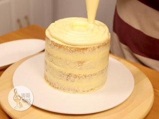 黄桃裙边蛋糕,15分钟过后把蛋糕从冰箱里取出开始进行真正的抹面环节，在上面挤上一圈奶油霜