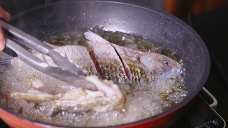 不一般的鲜美：宋嫂鱼羹,把鲫鱼和剔过的多宝鱼架一起放入油锅中炸至金黄色
