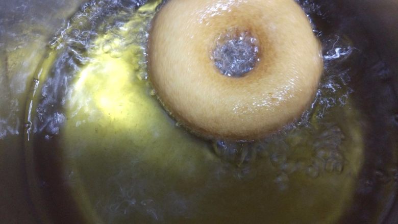 小黄人巧克力甜甜圈,热锅热油，烧到150度左右，小心地将二次发酵好的面包圈放入油中炸，中途翻面。我用的小油锅，耗油少，但是只能两个一起炸。