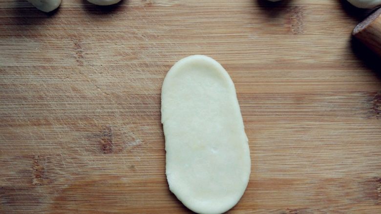 豆沙蛋黄酥,用两手稍揉成长条，用擀面杖小心地擀成长条。擀的时候用力要均匀，以免破皮