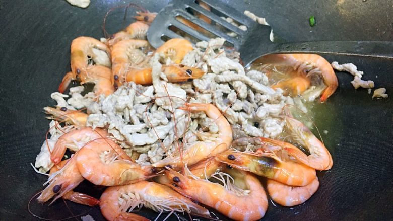 肉丝鲜虾炒面,锅里倒入适量的油，五六成热，先倒入肉丝过个油，然后倒入煮好的虾一起翻炒；