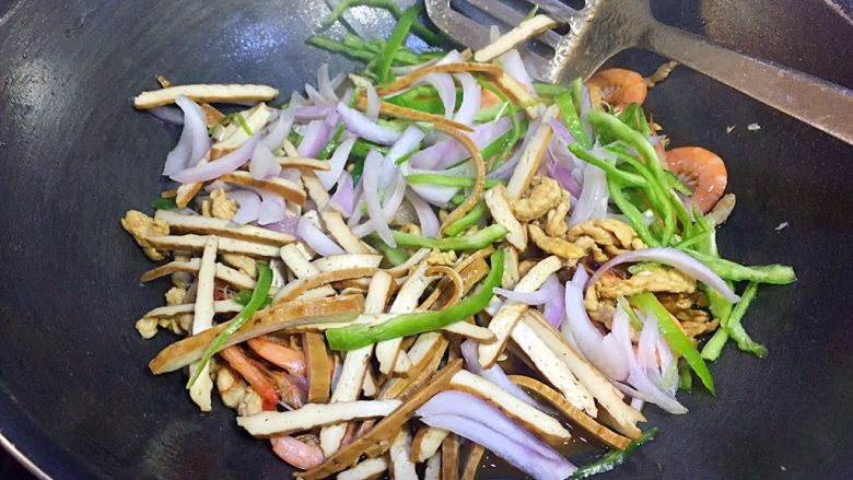 肉丝鲜虾炒面,豆干丝、洋葱丝、青椒丝一起倒入翻炒；