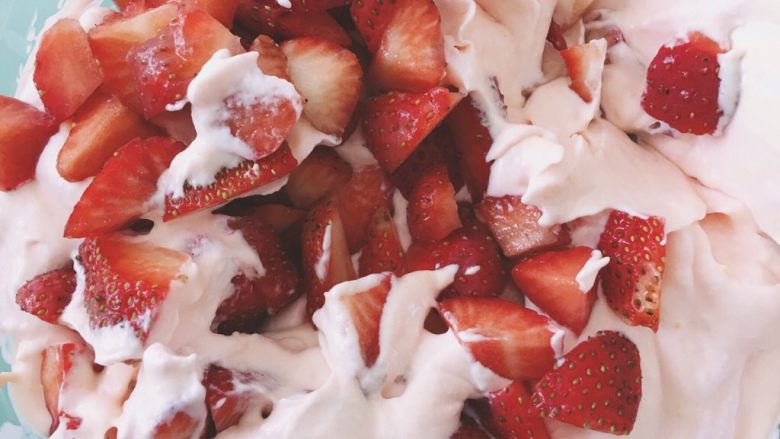 粉嫩的草莓冰激凌—无需烤箱系列,加入草莓丁，我切的太大了，小伙伴们一定要切小小的，或是不加哦～多少按自己的喜好～搅拌均匀