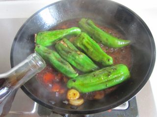 青椒酿肉,可以看到表面微微出了虎皮后 加入适量的料酒、少许水，炖煮两分钟；