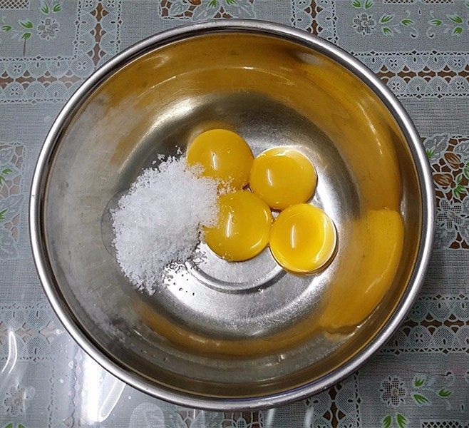 玉米面杂粮蛋糕,将蛋黄+16克砂糖放至盆中拌至砂糖融化