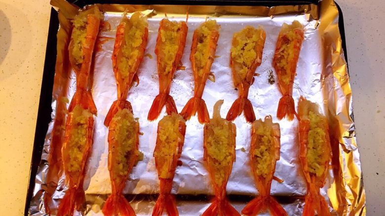 蒜蓉芝士阿根廷红虾#美食拔草大作战#,第六步 第二次加入调料（蒜泥、奶酪碎）
将蒜泥放入虾背，然后再铺一层马苏里拉奶酪碎。