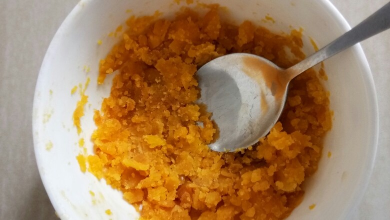 咸蛋黄焗南瓜,烤好的蛋黄用勺子碾碎备用。