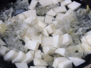 银耳雪梨羹,将泡发好的银耳控去多余的水份撕小朵 

锅内放入1000毫升清水 放入银耳和冰糖 煮至冰糖化开
