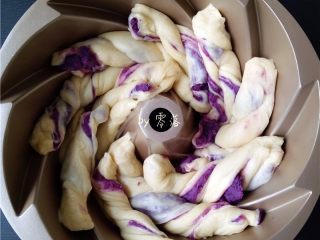 蜂蜜紫薯面包,将麻花状面团放入模具内；一条麻花状面团，对应放在一条凹槽内；