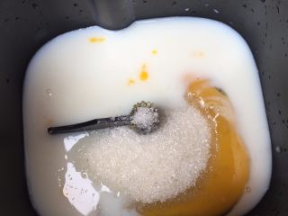 花朵豆沙面包,在面包机桶里，先放入液体的牛奶、鸡蛋还有淡奶油，加入白糖；