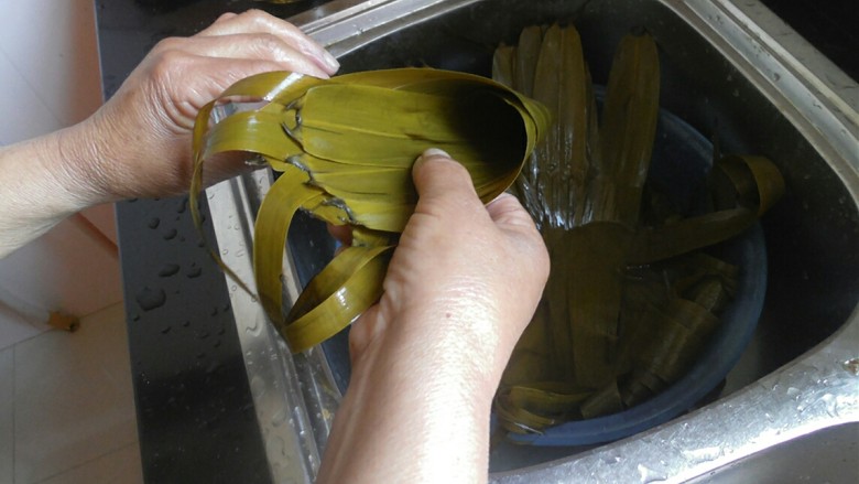 传统红枣粽,将粽叶自底部卷起，呈现一个漏斗形，注意漏斗下方一定要紧密，要不然会漏米的。