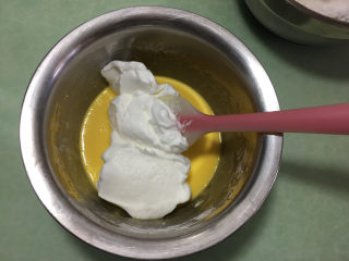 肉松蛋糕卷,取1/3蛋白霜放入蛋黄糊中（这时可以预热烤箱，温度为170度）。