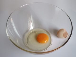 焦糖香蕉玛德琳花环,在打蛋盆里磕一个鸡蛋，鸡蛋要是常温的