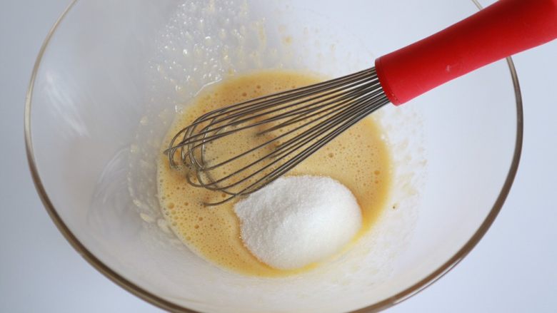焦糖香蕉玛德琳花环,混合均匀后加入细砂糖搅拌均匀，注意搅拌的过程不需要打发鸡蛋，都是混合均匀即可